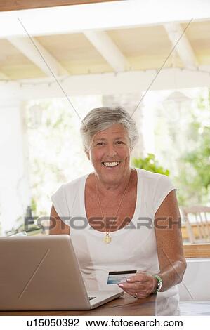 Older woman shopping online View Large Photo Image Stock Image - Older woman shopping online. Fotosearch