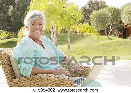 Older woman using laptop outdoors View Large Photo Image Stock Image - Older woman using laptop outdoors. Fotosearch