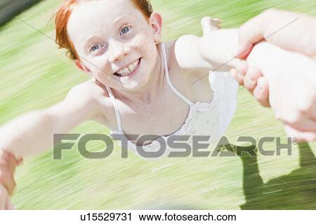 Parent swinging daughter in grass View Large Photo Image Stock Image - Parent swinging daughter in grass. Fotosearch