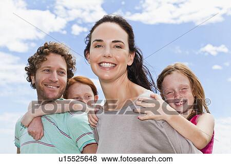 Stock Photo - Parents carrying daughters piggyback. Fotosearch