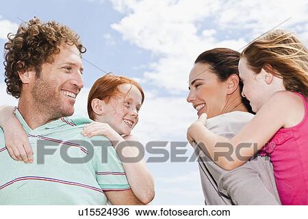 Stock Photograph - Parents carrying daughters piggyback. Fotosearch