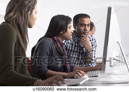Stock Image - People using computers at desk. Fotosearch