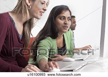 Stock Image - People using computers at desk. Fotosearch