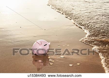 Stock Image - Piggy bank washed up on beach. Fotosearch
