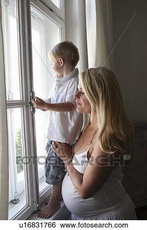 Pregnant mother and son at window View Large Photo Image Stock Photograph - Pregnant mother and son at window. Fotosearch