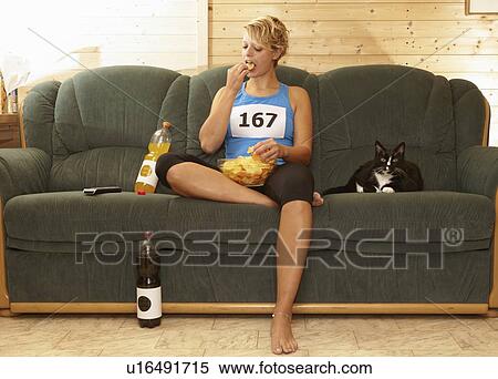 Runner eating chips on sofa View Large Photo Image Stock Photography - Runner eating chips on sofa. Fotosearch