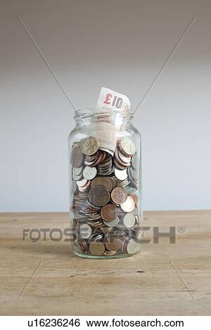 Savings jar on desk View Large Photo Image Stock Photograph - Savings jar on desk. Fotosearch