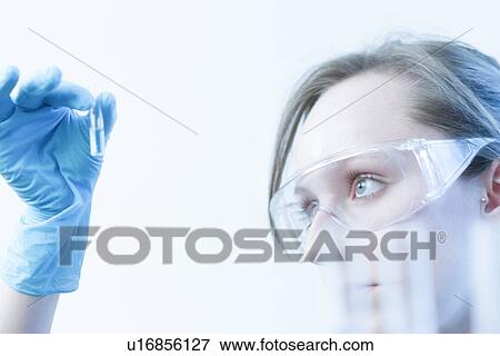 Stock Photo - Scientist examining test tube in lab. Fotosearch