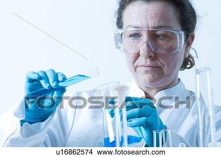 Scientist pouring liquid into beaker View Large Photo Image Picture - Scientist pouring liquid into beaker. Fotosearch