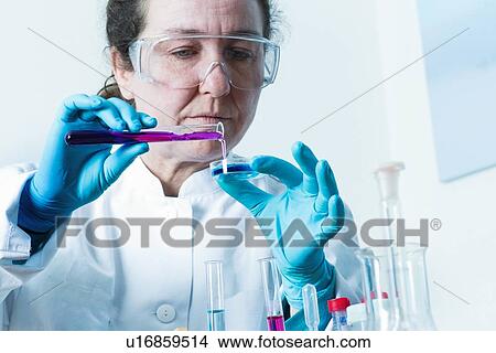 Picture - Scientist pouring liquid into petri dish. Fotosearch