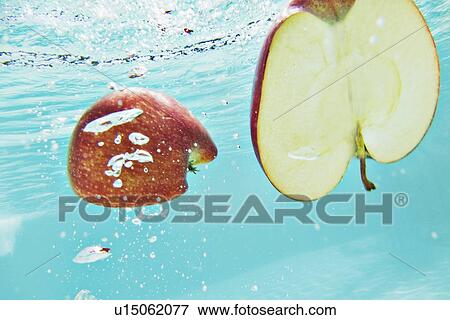 Sliced apple splashing into water View Large Photo Image Stock Photo - Sliced apple splashing into water. Fotosearch