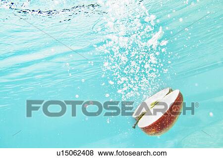 Stock Photo - Sliced apple splashing into water. Fotosearch