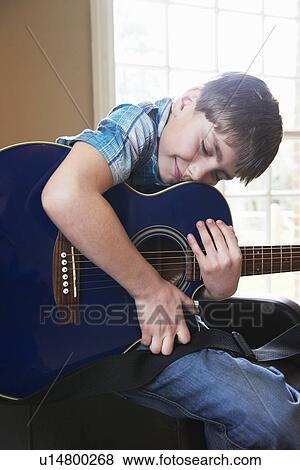 Smiling boy hugging guitar View Large Photo Image Stock Photo - Smiling boy hugging guitar. Fotosearch