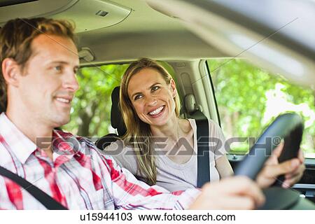 Stock Image - Smiling couple riding in car. Fotosearch