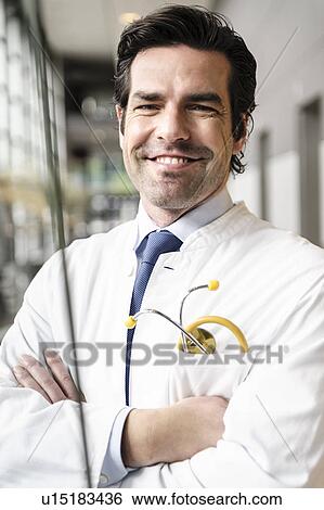 Smiling doctor standing in hallway View Large Photo Image Stock Photograph - Smiling doctor standing in hallway. Fotosearch