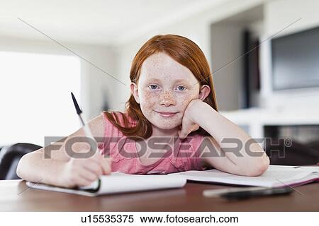Stock Photography - Smiling girl doing homework. Fotosearch