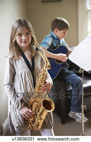 Stock Image - Smiling girl playing saxophone. Fotosearch