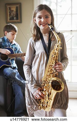 Smiling girl playing saxophone View Large Photo Image Stock Image - Smiling girl playing saxophone. Fotosearch