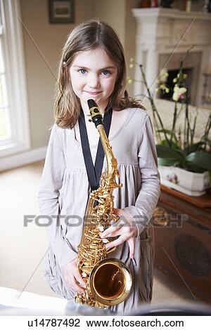 Stock Image - Smiling girl playing saxophone. Fotosearch