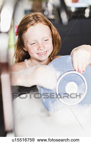 Stock Photo - Smiling girl washing plate in sink. Fotosearch