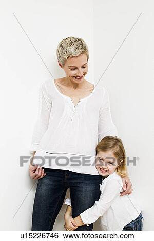 Stock Photograph - Smiling mother and daughter hugging. Fotosearch