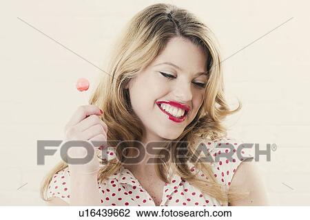 Smiling woman eating lollipop View Large Photo Image Stock Image - Smiling woman eating lollipop. Fotosearch
