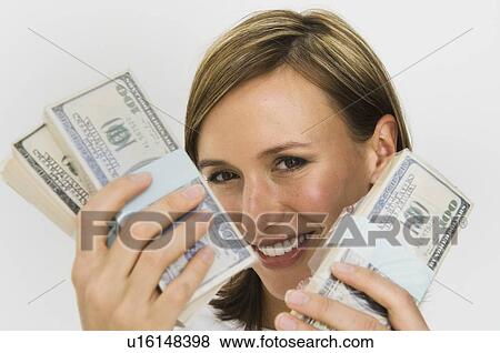 Smiling woman holding wads of cash View Large Photo Image Stock Photo - Smiling woman holding wads of cash. Fotosearch