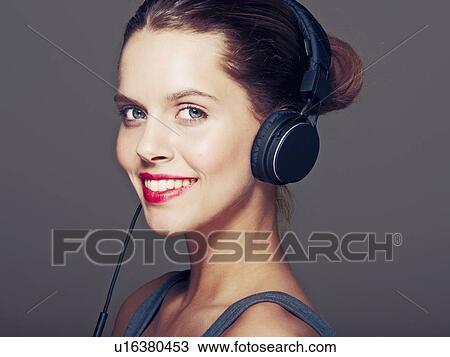 Smiling woman wearing headphones View Large Photo Image Stock Image - Smiling woman wearing headphones. Fotosearch