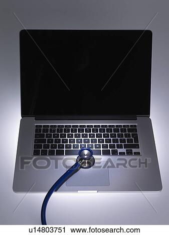Stock Image - Stethoscope on laptop computer. Fotosearch
