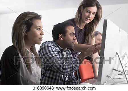 Teacher helping students use computers View Large Photo Image Stock Photo - Teacher helping students use computers. Fotosearch