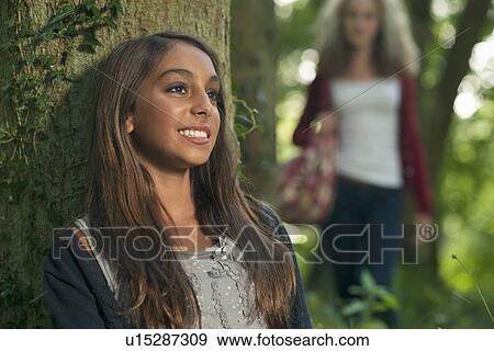 Teenage girl leaning on tree in forest View Large Photo Image Stock Photo - Teenage girl leaning on tree in forest. Fotosearch