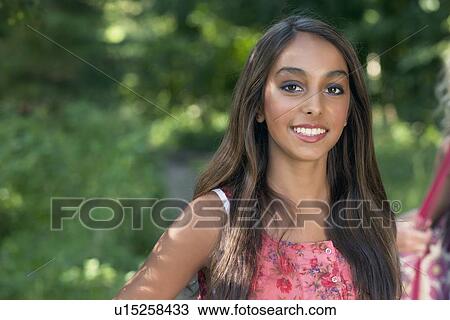 Stock Image - Teenage girl smiling outdoors. Fotosearch