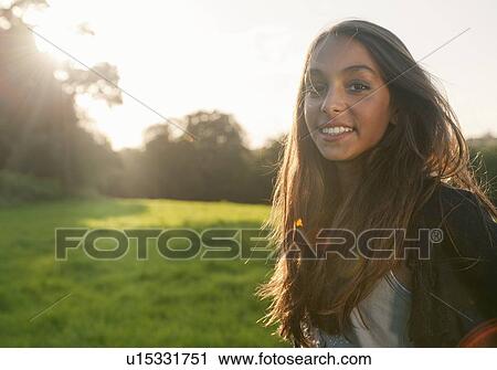 Stock Image - Teenage girl standing in field. Fotosearch