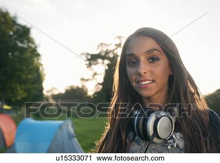 Stock Image - Teenage girl wearing headphones outdoors. Fotosearch
