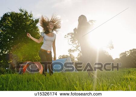 Picture - Teenage girls dancing in field. Fotosearch