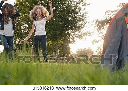Stock Image - Teenage girls dancing in field. Fotosearch