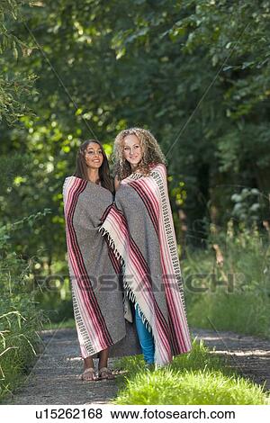 Teenage girls in blanket on rural road View Large Photo Image Stock Photo - Teenage girls in blanket on rural road. Fotosearch