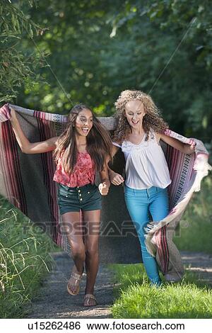 Stock Photograph - Teenage girls in blanket on rural road. Fotosearch