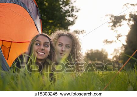 Stock Photography - Teenage girls laying in tent at campsite. Fotosearch