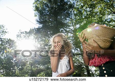 Teenage girls playing with straw hat View Large Photo Image Stock Photo - Teenage girls playing with straw hat. Fotosearch