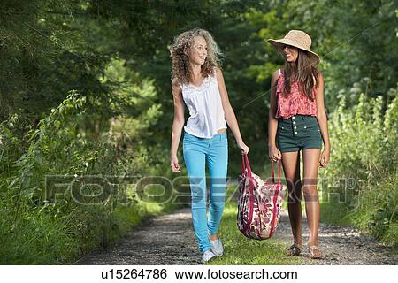 Stock Photograph - Teenage girls walking on rural road. Fotosearch