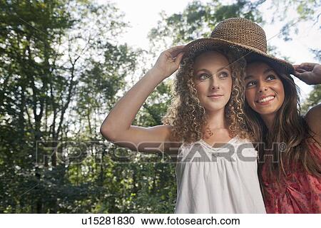 Teenage girls wearing straw hat outdoors View Large Photo Image Stock Image - Teenage girls wearing straw hat outdoors. Fotosearch