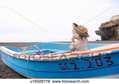 Toddler girl sitting in boat on beach View Large Photo Image Stock Photo - Toddler girl sitting in boat on beach. Fotosearch