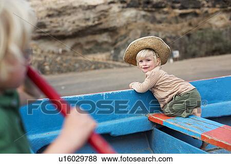 Toddler girl sitting in boat on beach View Large Photo Image Stock Photo - Toddler girl sitting in boat on beach. Fotosearch