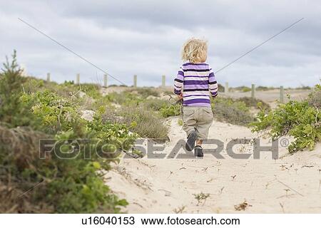 Toddler girl walking on beach View Large Photo Image Stock Image - Toddler girl walking on beach. Fotosearch
