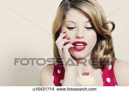 Picture - Woman admiring cupcake indoors. Fotosearch