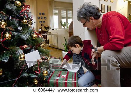 Stock Photo - Woman and grandson with Christmas presents. Fotosearch