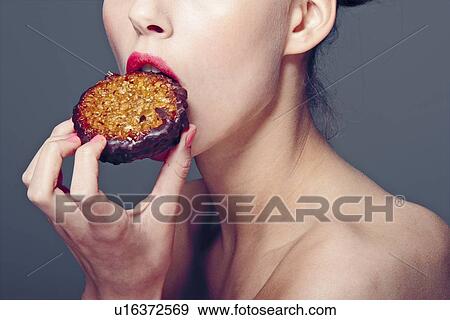 Stock Photo - Woman eating cookie. Fotosearch