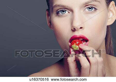 Stock Photograph - Woman eating strawberry. Fotosearch