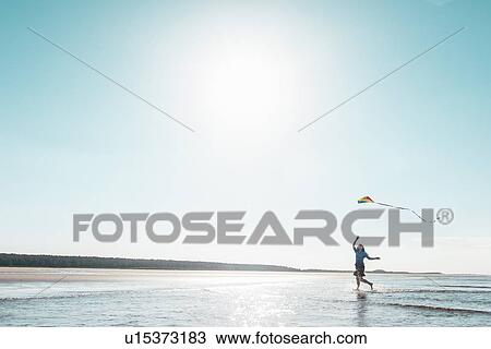 Woman flying kite on beach View Large Photo Image Stock Image - Woman flying kite on beach. Fotosearch